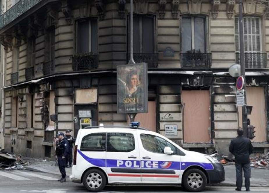 Policemen stand guard outside a burnt bank agency at the corner of Rue du Colisee and boulevard Roosevelt, near the Champs-Elysees avenue in Paris on March 17, 2019. (Photo by AFP)