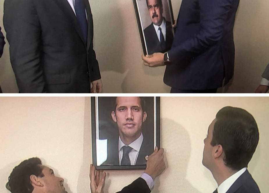 Opposition envoy Carlos Vecchio (L) and an aide replace the picture of Venezuelan President Nicolas Maduro with a picture of self-declared "Interim President" Juan Guaido after occupying a Venezuelan diplomatic building in Washington, DC, on March 18, 2019. (Photo by Reuters)
