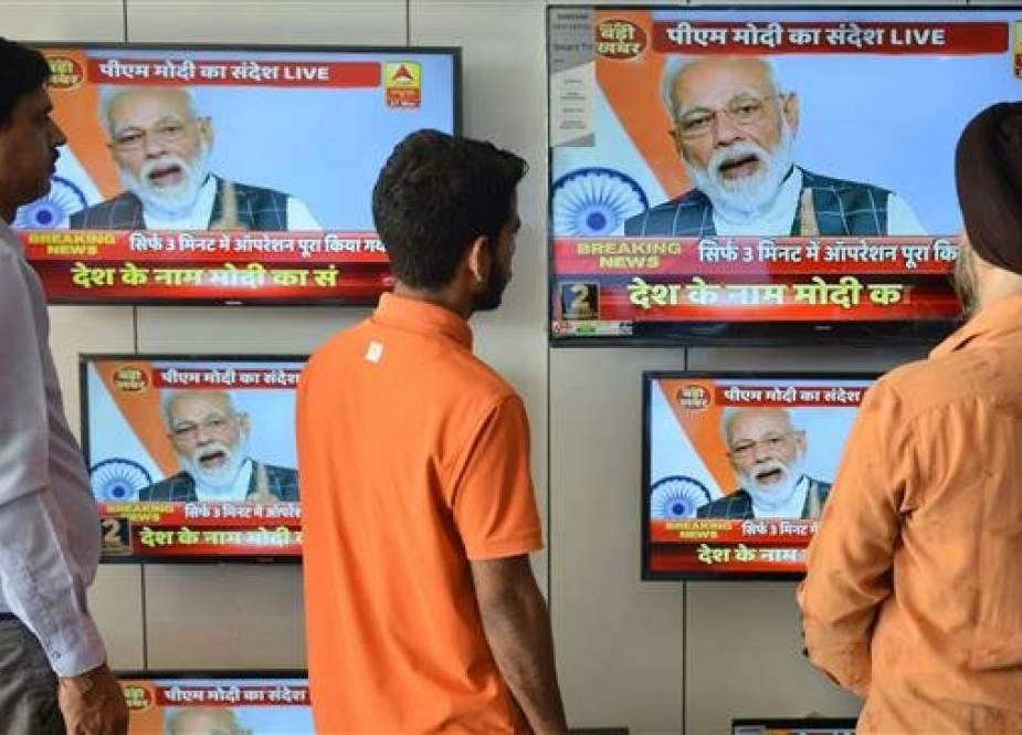 People watch the live broadcast of Indian Prime Minister Narendra Modi addressing the nation on televisions displayed in an electronic store in Amritsar on March 27, 2019. (Photo by AFP)