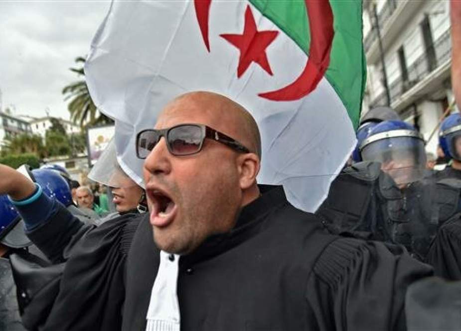 An Algerian lawyer shouts slogans and raises the national flag during a demonstration against ailing President Abdelaziz Bouteflika in the centre of the capital Algiers on March 23, 2019. (AFP photo)
