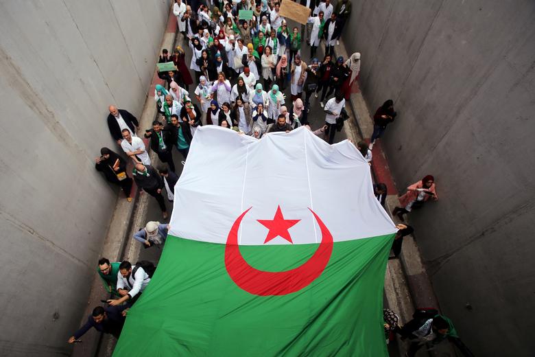 Health workers carry a national flag as they march during a protest calling on President Bouteflika to quit, in Algiers, March 19. Algeria has transformed during the protests, with people losing fear of criticizing the government and state media first ig