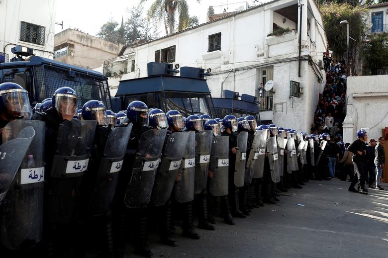 Anti-riot police officers stand guard during a protest to demand the resignation of President Bouteflika, in Algiers, March 29