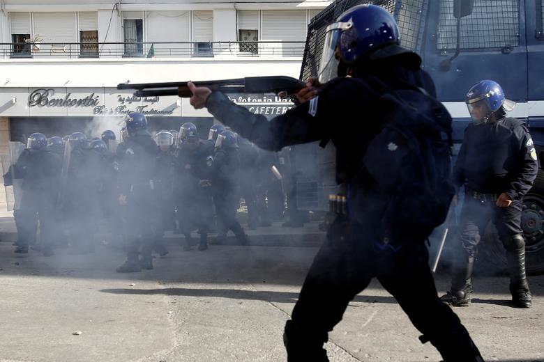 Anti-riot police officers clash with people protesting to demand the resignation of President Abdelaziz Bouteflika, in Algiers, March 29