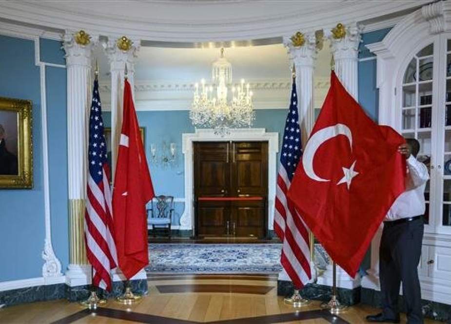 A State Department staffer adjusts a Turkish flag before a meeting between US Secretary of State Mike Pompeo and Turkish Foreign Minister Mevlut Cavusoglu at the US Department of State in Washington, DC on April 3, 2019. (Photo by AFP)