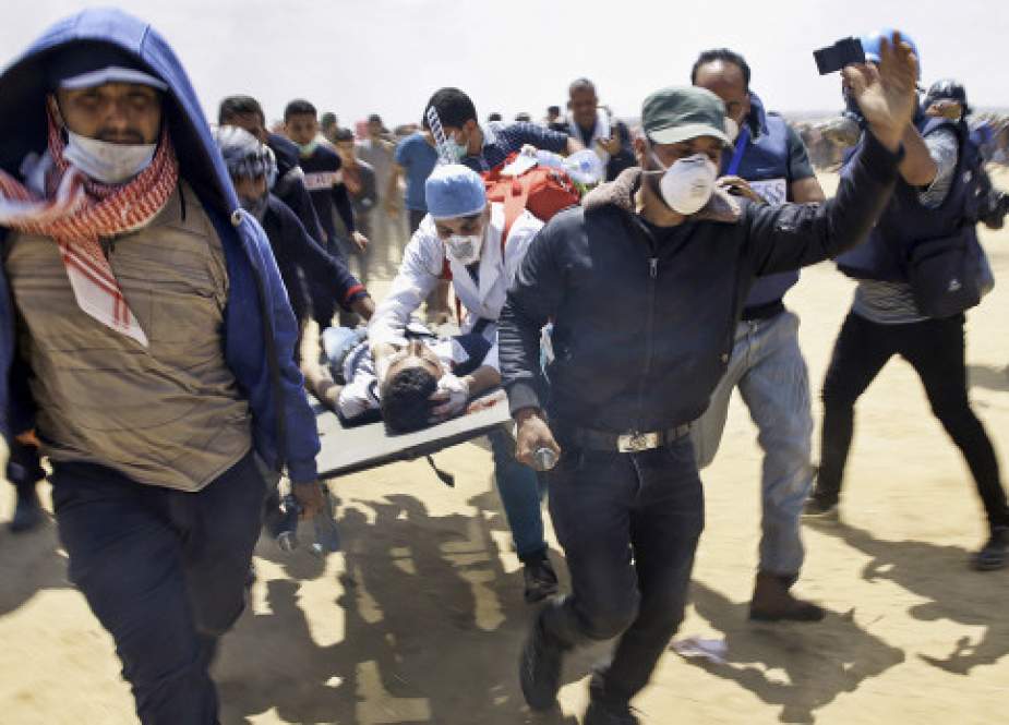 Palestinian paramedics carry away a child hit by Israeli forces during a demonstration along the fence between the Gaza Strip and the occupied territories, east of Khan Younis, in the southern Gaza Strip, on April 5, 2019.