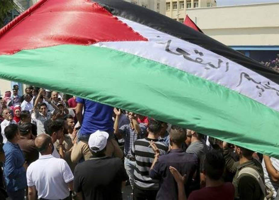 Palestinian refugees hold flags as they chant slogans during a protest in Amman, Jordan, on September 2, 2018. (Photo by AP)