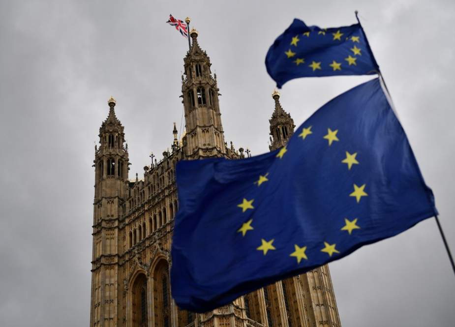 The Union flag flies atop the Houses of Parliament as EU flags held by demonstrators flutter in central London on April 4, 2019. (AFP photo)