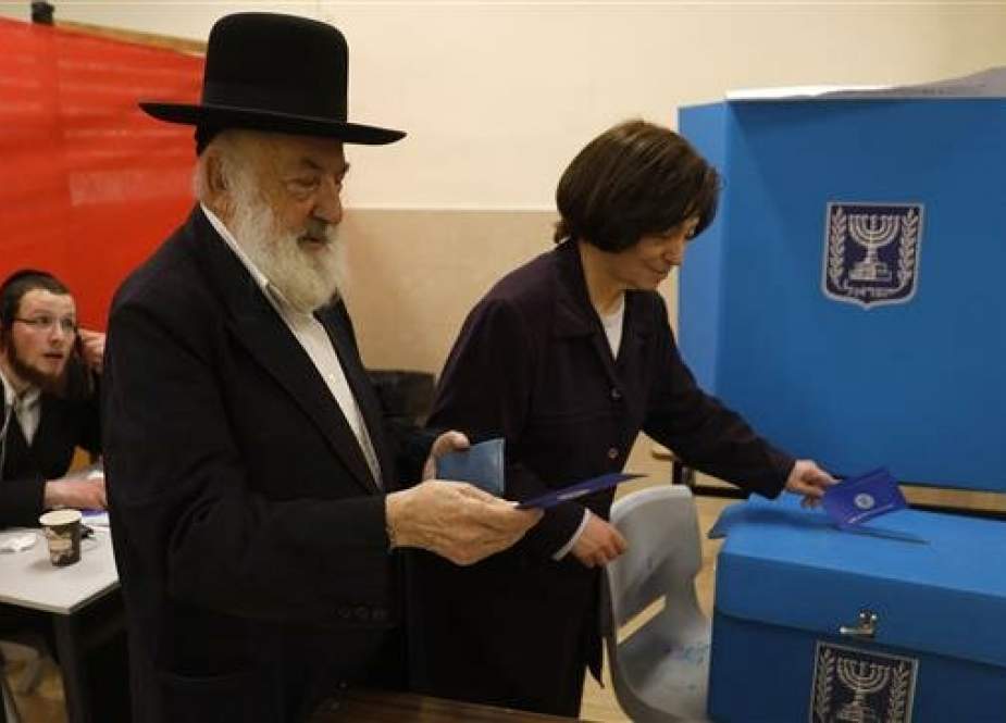 An ultra-Orthodox man and a woman cast their vote during Israel