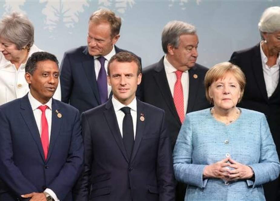 British Prime Minister Theresa May (top L), European Council President Donald Tusk (top 2nd L), German Chancellor Angela Merkel (bottom R), French President Emmanuel Macron (C), UN Secretary-General António Guterres (top 2nd R), International Monetary Fund Managing Director Christine Lagarde (top R) and other heads of state gather for a family photo during the G7 Outreach summit in La Malbaie, Quebec, June 9, 2018. (Photo by AFP)