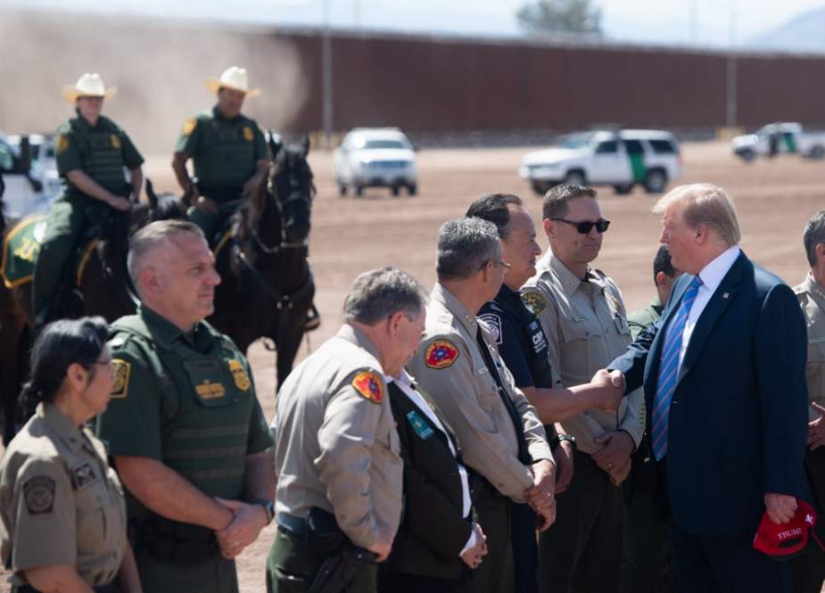 US President Donald Trump speaks with members of the US Customs and Border Patrol as he tours the border wall between the United States and Mexico in Calexico, California on April 5, 2019. (Photo by AFP)