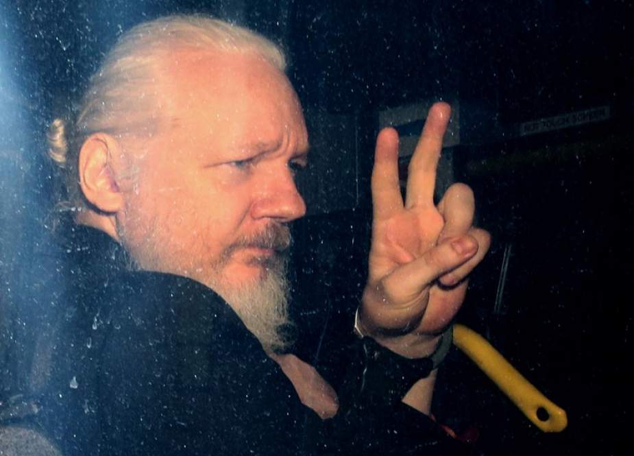 Julian Assange memberi isyarat kepada media dari kendaraan polisi pada saat kedatangannya di Pengadilan Magistrasi Westminster pada 11 April 2019, di London.
Jack Taylor / Getty Images