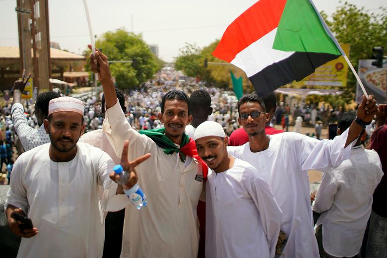 Sudanese demonstrators pose for a photograph as they protest against the army's announcement that President Omar al-Bashir would be replaced by a military-led transitional council, ahead of the Friday prayers near the Defence Ministry in Khartoum, April 
