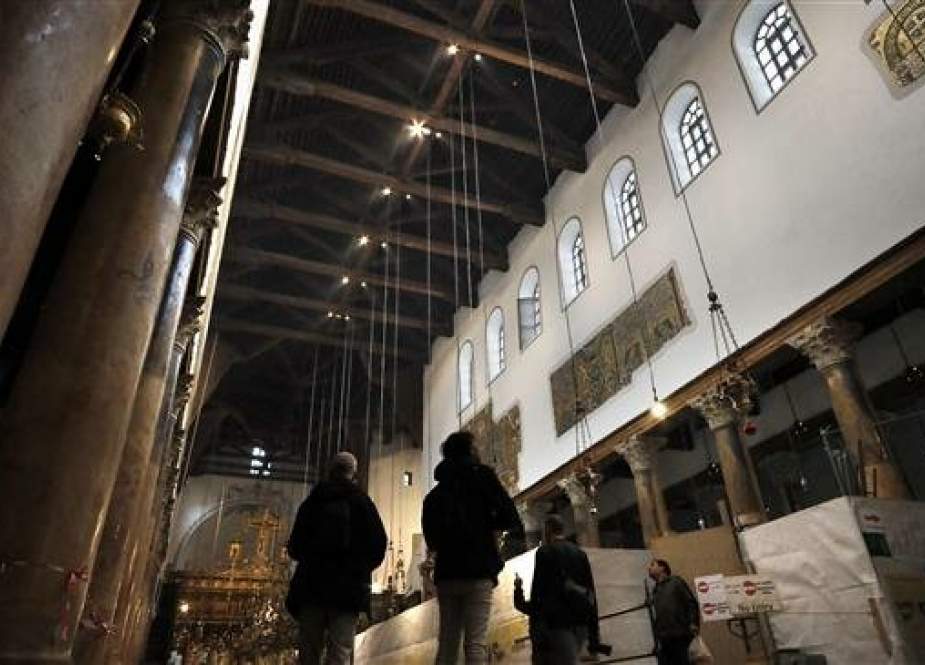 Visitors observe the wooden structure inside the Church of the Nativity in the occupied West Bank city of Bethlehem, on April 16, 2019. (Photo by AFP)