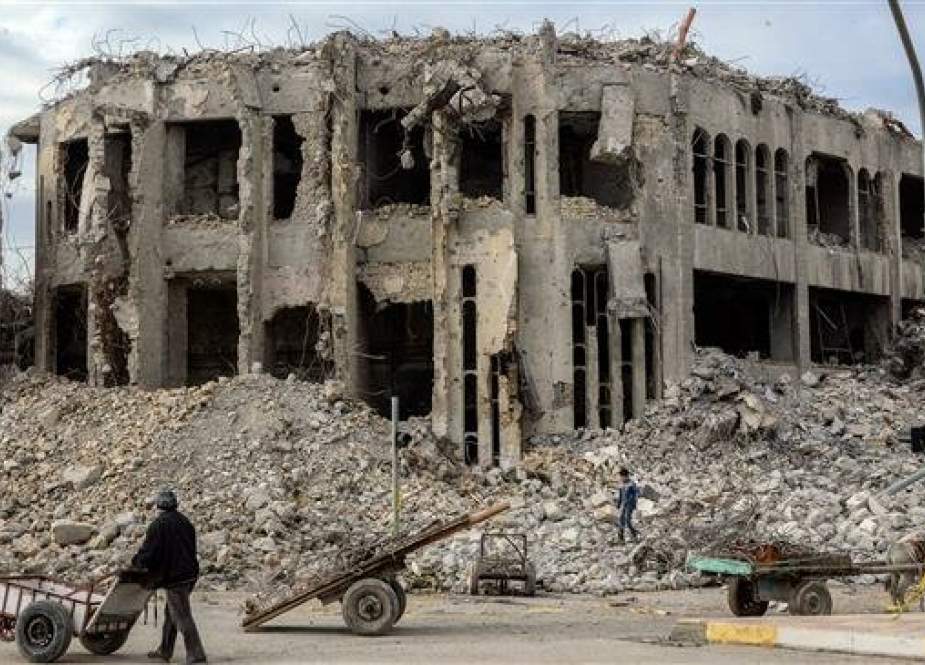 An Iraqi pushes his cart past the rubble of the destroyed seven-storey Chadirji Building, designed by celebrated Iraqi architect Rifat Chadirji in the 1960s, on January 13, 2019, in the city of Mosul. (Photo by AFP)