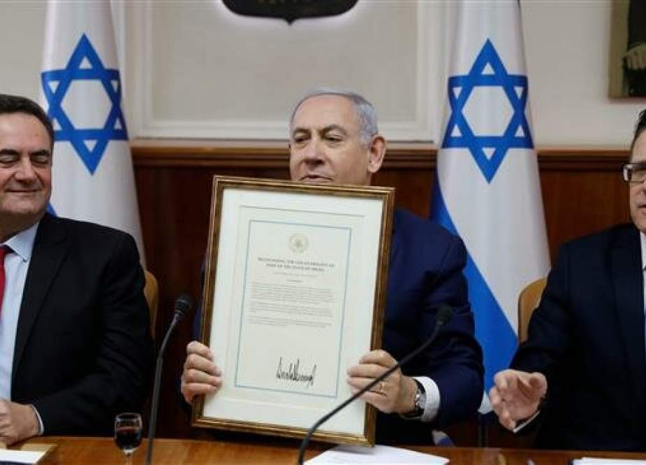 Israeli Prime Minister Benjamin Netanyahu (C) holds a proclamation signed by US President Donald Trump recognizing Israel