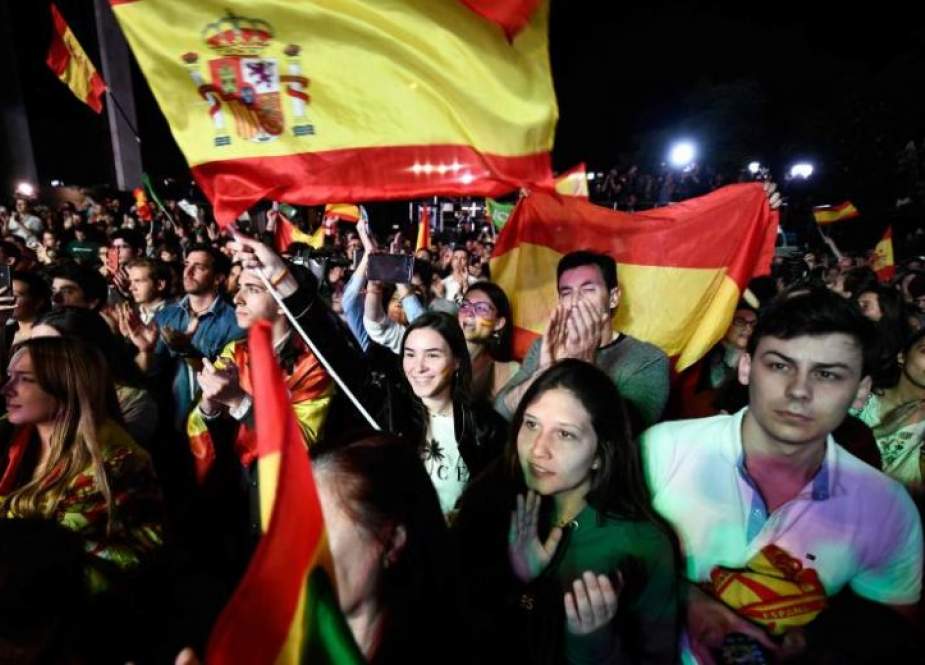 Supporters of Spanish far-right VOX party wave flags as they listen to their leader and candidate for prime minister Santiago Abascal delivering a speech during an election night rally in Madrid after Spain held general elections on April 28, 2019. (Photo by AFP)
