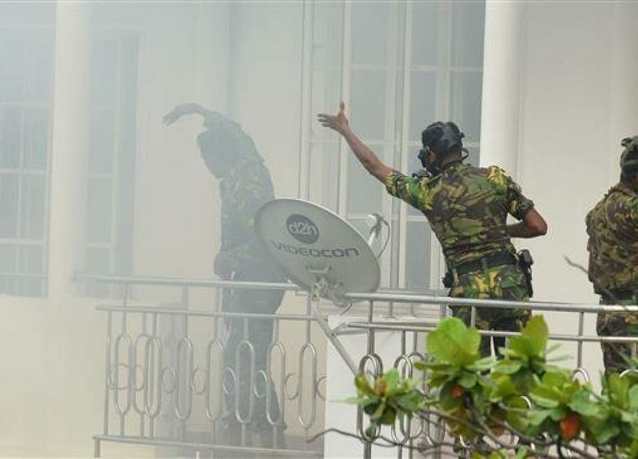 Sri Lankan Special Task Force (STF) personnel gesture outside a house during a raid in the Orugodawatta area of the capital, Colombo, April 21, 2019. (Photo by AFP)