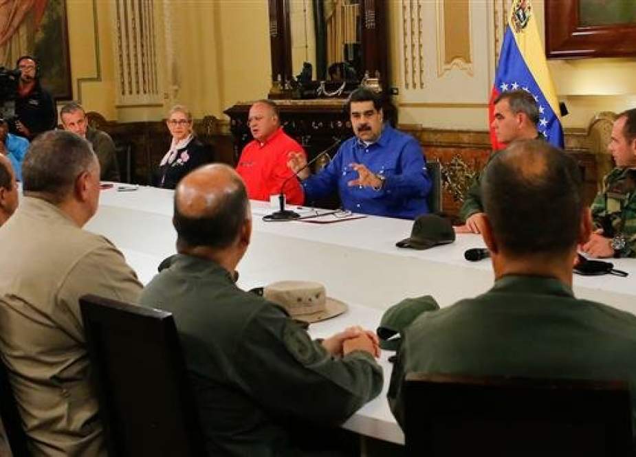 Venezuela’s President Nicolas Maduro speaks with members of the Military High Command around him during a broadcast at the Miraflores Palace in Caracas, on April 30, 2019. (Photo by AFP)