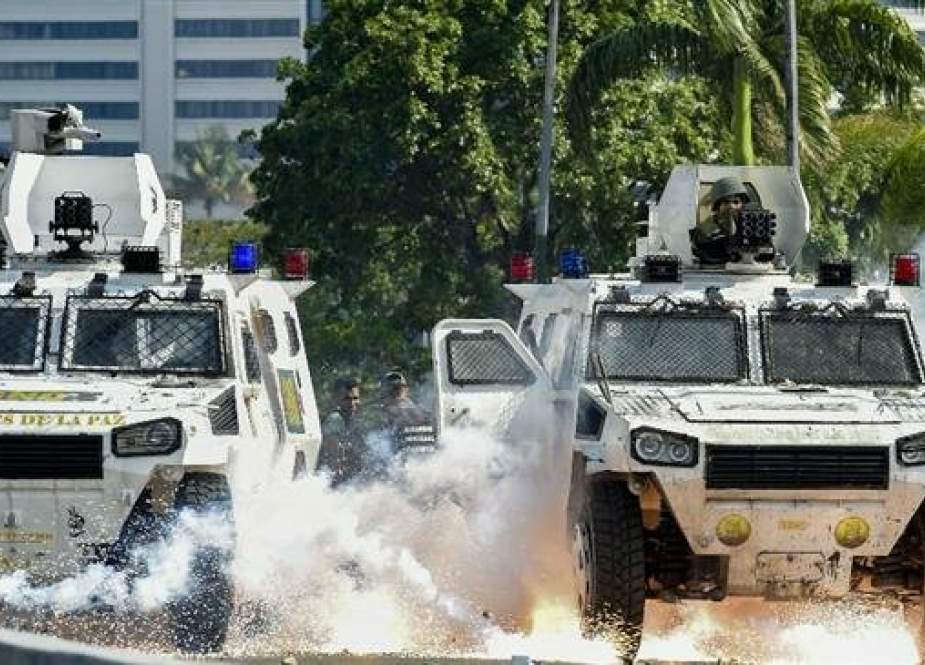 An explosion occurs under a military vehicle during clashes in Caracas on April 30, 2019. (Photo by AFP)
