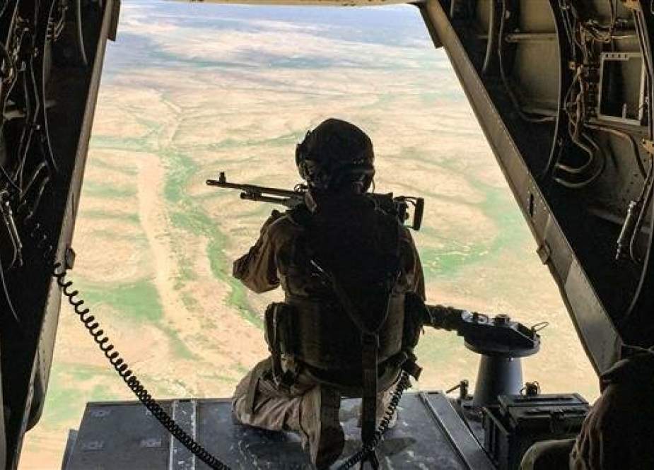 A gunner mans a machine gun at the back of a US Marine Corps V-22 Osprey flying near a French artillery base near al-Qaim in Iraq