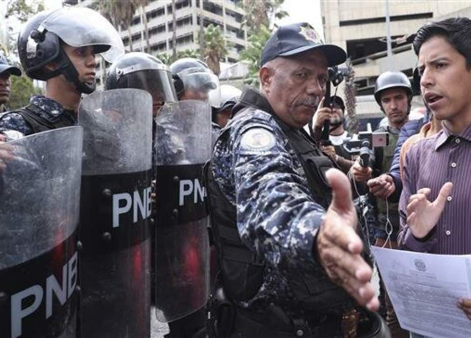 A police officer blocks a protester outside the Venezuelan Navy’s headquarter in the capital, Caracas, on May 4, 2019. (Photo by AP)