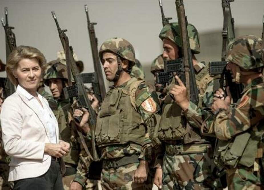 German Defense Minister Ursula von der Leyen (L) stands among Kurdish Peshmerga and German Bundeswehr soldiers during a visit to the educational center Bnaslawa near Irbil, Iraq, in September 2016.
