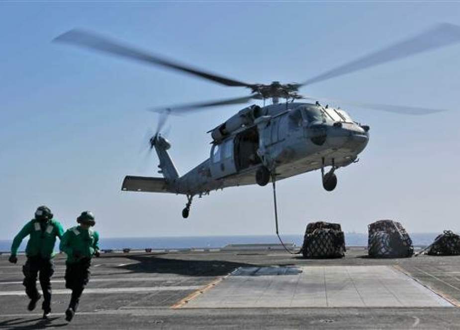 This handout picture released by the US Navy on May 10, 2019 shows naval logistics specialists attaching cargo to an MH-60S Sea Hawk helicopter from the "Nightdippers" of Helicopter Sea Combat Squadron (HSC) 5 from the flight deck of the Nimitz-class aircraft carrier USS Abraham Lincoln (CVN 72).