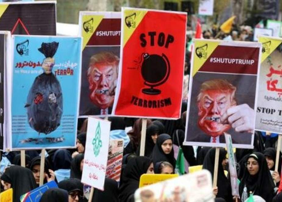 Iranian women carry placards, some bearing the portrait of US President Donald Trump, during a demonstration outside the former US embassy in the Iranian capital Tehran on November 4, 2017. (Photo by AFP)