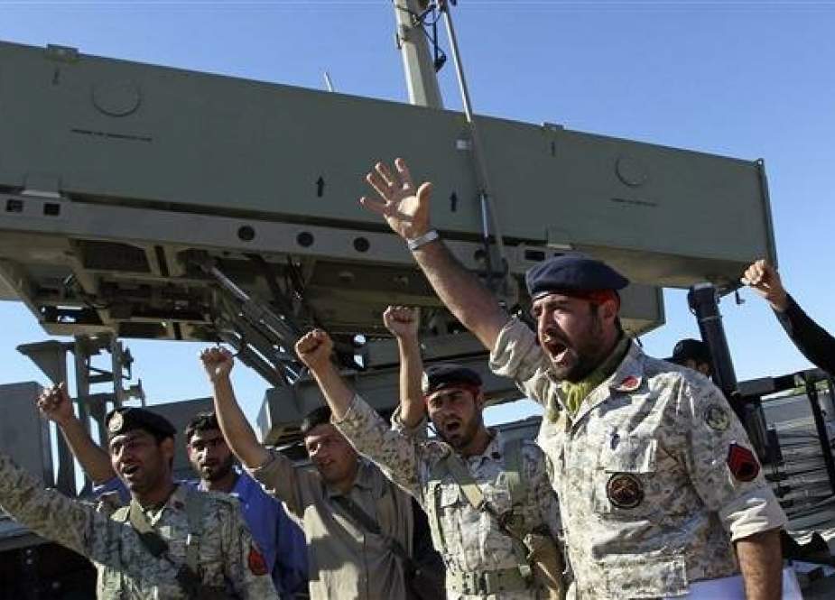 Iranian Navy personnel celebrate after successfully launching a missile from the Jask Port, during a drill near the Strait of Hormuz, on January 1, 2013. (Photo via AP)