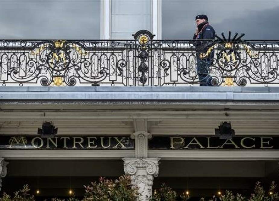 A private security guard is seen above the entrance of The Fairmont Le Montreux Palace hotel in Montreux on May 29, 2019, which is scheduled to host the annual Bilderberg Meeting. (Photo by AFP)