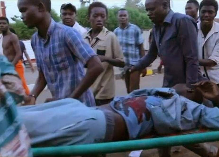 A photo grab taken from a video posted on social media shows Sudanese protesters carrying a wounded protester during clashes with security forces near army headquarters in Khartoum, Sudan, on June 3, 2019. (Via AFP)
