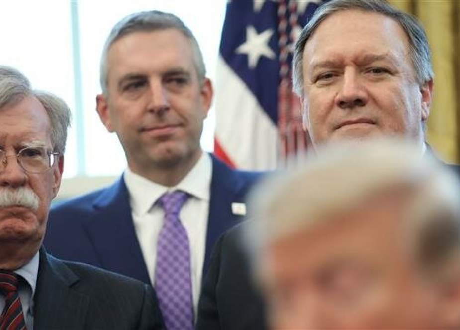 US National Security Adviser John Bolton (L) and Secretary of State Mike Pompeo (R) look on as US President Donald Trump signs a National Security Presidential Memorandum in the Oval Office on February 7, 2019 in Washington, DC. (Photo by AFP)