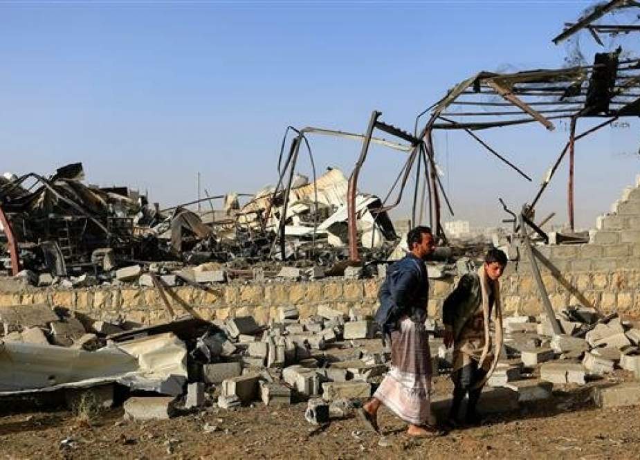 Civilians inspect the damage at a factory after an airstrike by Saudi-led coalition in the Yemeni capital Sana