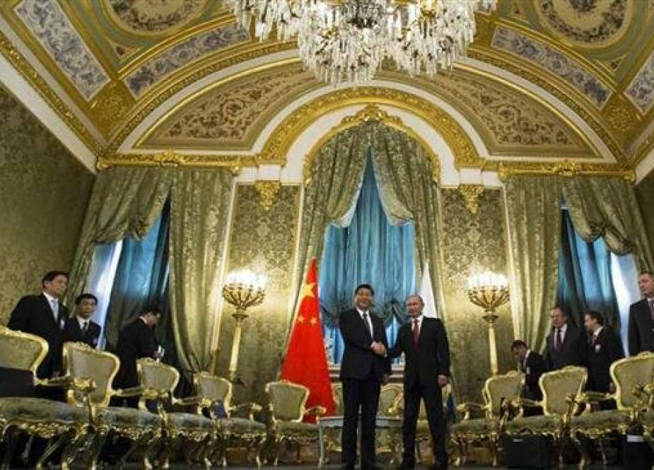Russian President Vladimir Putin (R) and his Chinese counterpart Xi Jinping shake hands in the impressive St George Hall in the Kremlin.