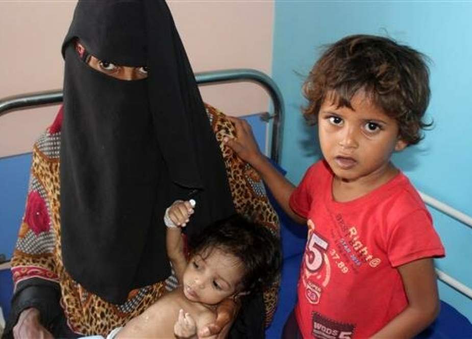 A Yemeni woman sits with one of her children as she carries another malnourished one at a hospital in the western Yemeni province of al-Hudaydah on January 21, 2019. (Photo by AFP)