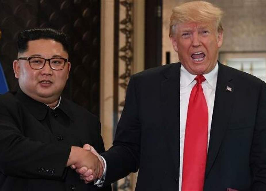 In this file photo, taken on June 12, 2018, US President Donald Trump (R) and North Korea’s leader Kim Jong-un shake hands following a signing ceremony during a historic summit at the Capella Hotel on Sentosa Island in Singapore. (By AFP)