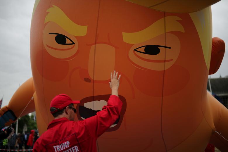 A man is seen in front of a 'Baby Trump' balloon during an anti-Trump protest in London, June 4