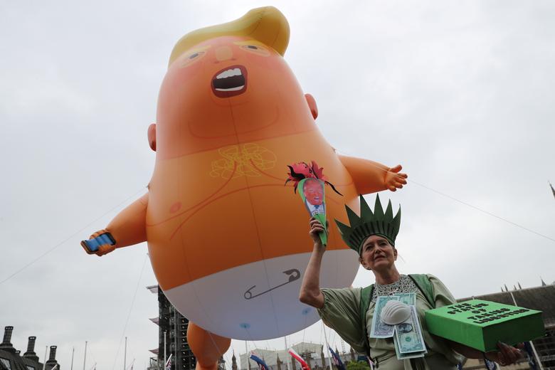 A 'Baby Trump' balloon flies over a demonstrator as she takes part in an anti-Trump protest in London, June 4