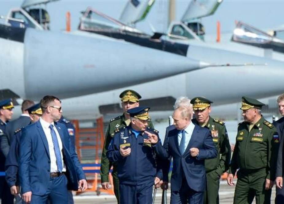 Russian President Vladimir Putin, surrounded by top military officers and officials, tours a military flight test centre in Akhtubinsk on May 14, 2019. (Photo by AFP)