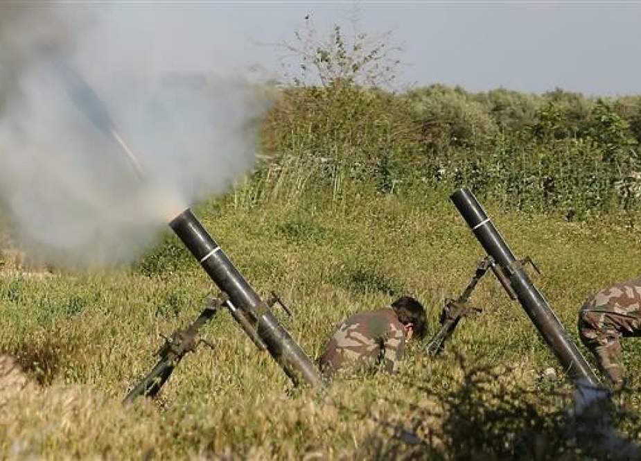 File photo of Turkish-backed Hamza militants firing a mortar from Syria (Photo by AFP)