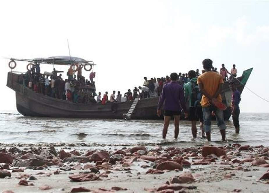 This photograph taken on October 15, 2018 shows people getting off a boat in Bhashan Char island off the Bangladeshi coast, as it was being prepared for the relocation of Rohingya refugees living in the country