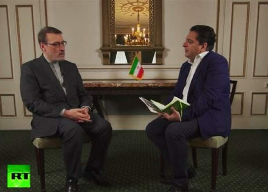 Iran’s ambassador to the United Kingdom, Hamid Baeidinejad, (L) talks to Russia Today’s Afshin Rattansi during an interview released on June 19, 2019.