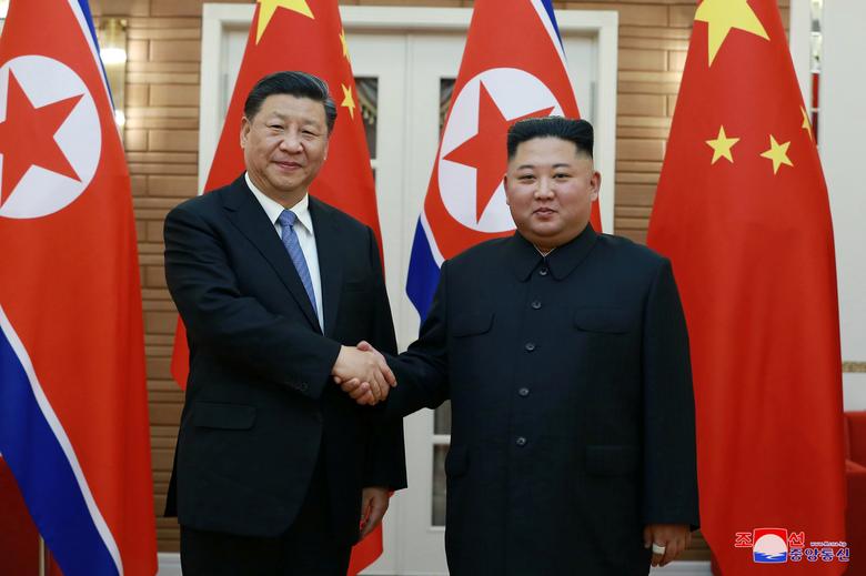North Korean leader Kim Jong Un shakes hands with China's President Xi Jinping during Xi's visit in Pyongyang