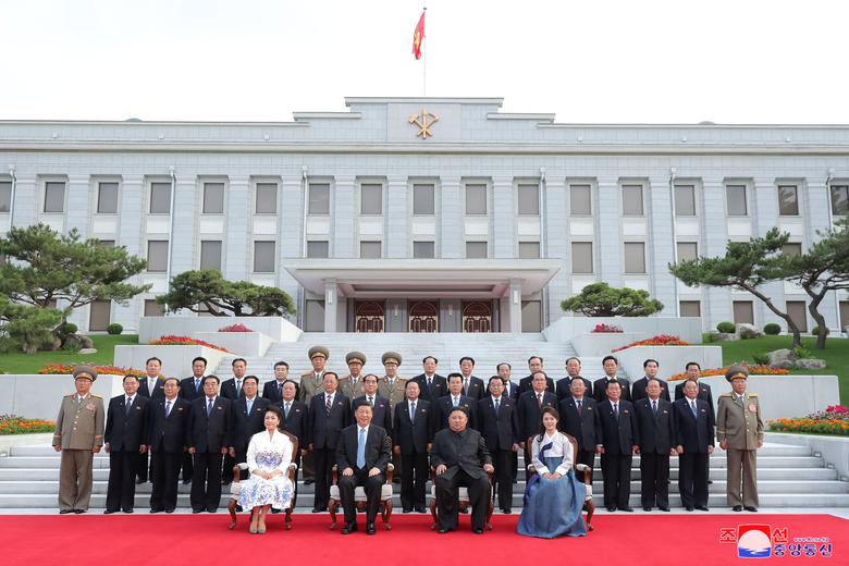 North Korean leader Kim Jong Un and wife Ri Sol Ju pose for a group photo with China's President Xi Jinping and wife Peng Liyuan along with North Korean officials during Xi's visit in Pyongyang
