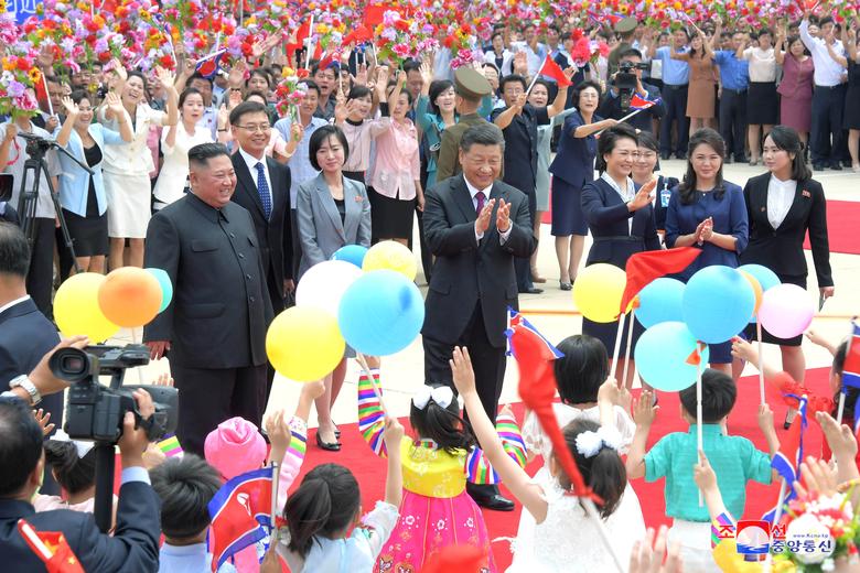 North Korean leader Kim Jong Un welcomes Chinese President Xi Jinping at the Pyongyang International Airport. Also pictured are Kim's wife Ri Sol Ju and Xi's wife Peng Liyuan