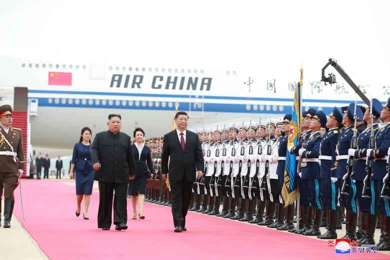 North Korean leader Kim Jong Un welcomes Chinese President Xi Jinping at the Pyongyang International Airport. Also pictured are Kim's wife Ri Sol Ju and Xi's wife Peng Liyuan