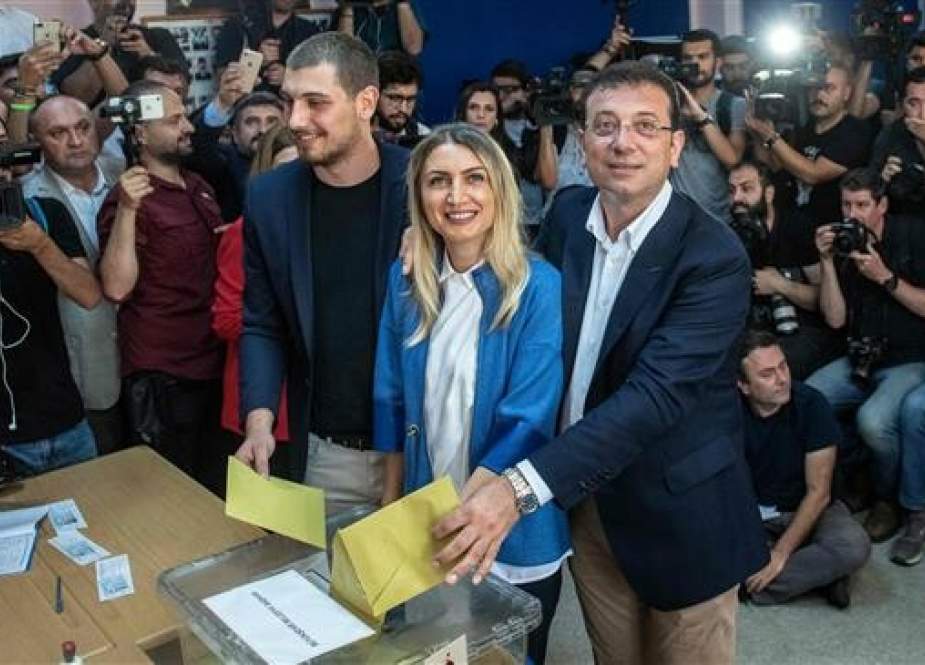 Istanbul mayoral candidate of the main opposition Republican People’s Party (CHP) Ekrem Imamoglu (C-R) casts his vote with his wife, Dilek Imamoglu (C), and their son Semih Imamoglu, in Istanbul, Turkey, on June 23, 2019. (Photo by AFP)