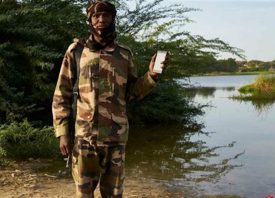 The file photo, taken in front of Lake Chad on November 7, 2018, shows a Chadian soldier posing with a mobile phone. (AFP)