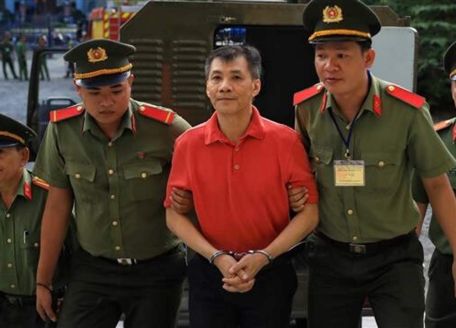 US citizen Michael Phuong Minh Nguyen, 55 and clad in red, is escorted by policemen on June 24, 2019 to a court in Ho Chi Minh city, Vietnam. (Photo by Reuters)