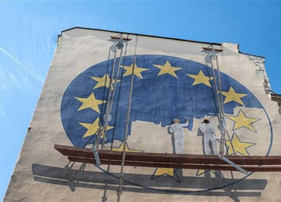 A trompe l’oeil shows two workers painting the European Union flag on May 23, 2019 in Paris, France. (By AFP)